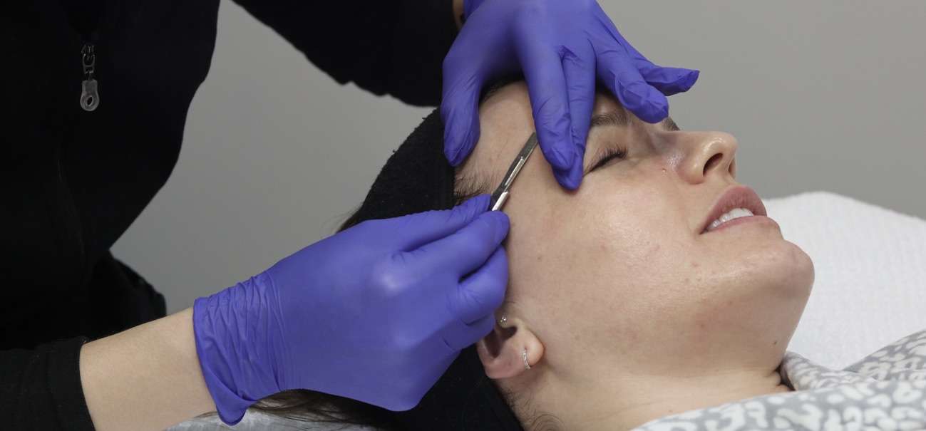 Dermaplaning service on client