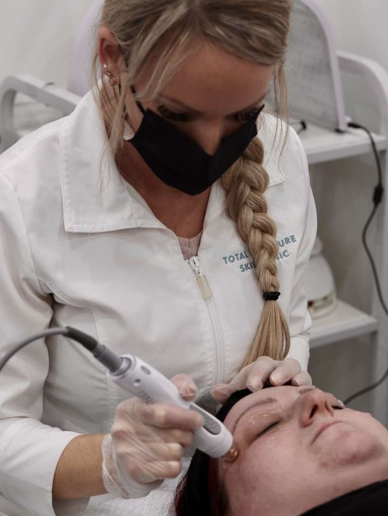 Esthetician performing eye service on client