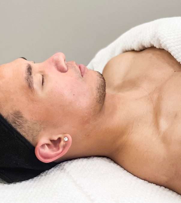 Man with eyes closed on facial table