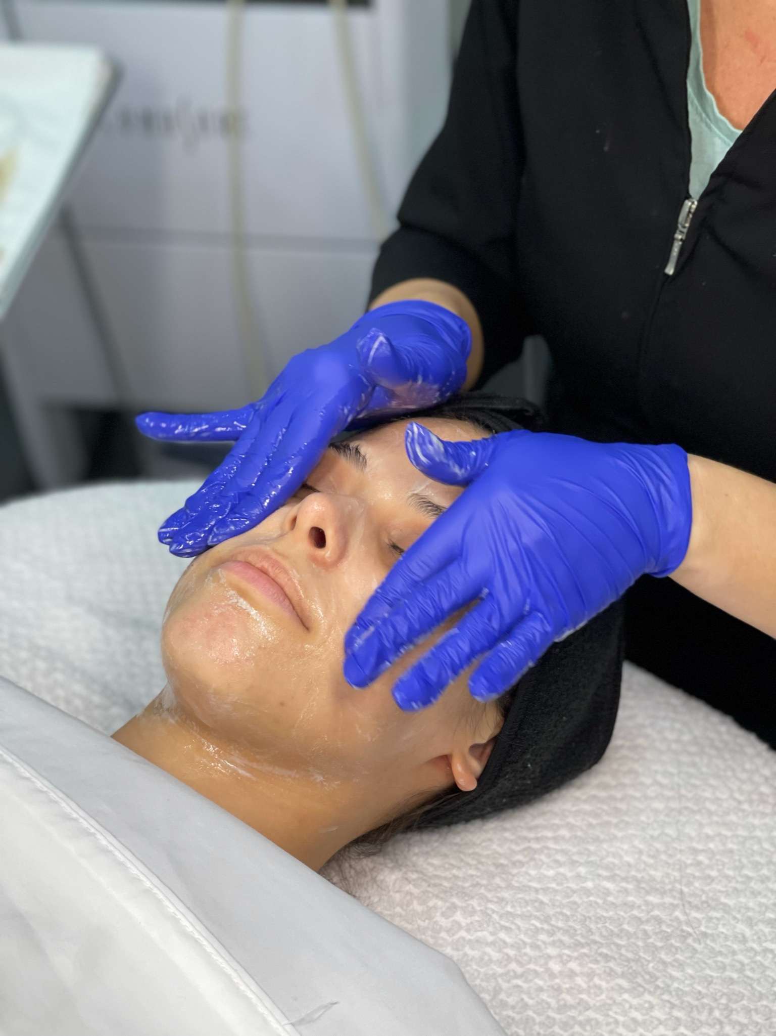 Esthetician performing a facial on client