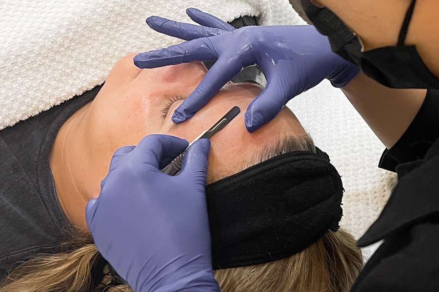 Woman getting a dermaplaning facial service.