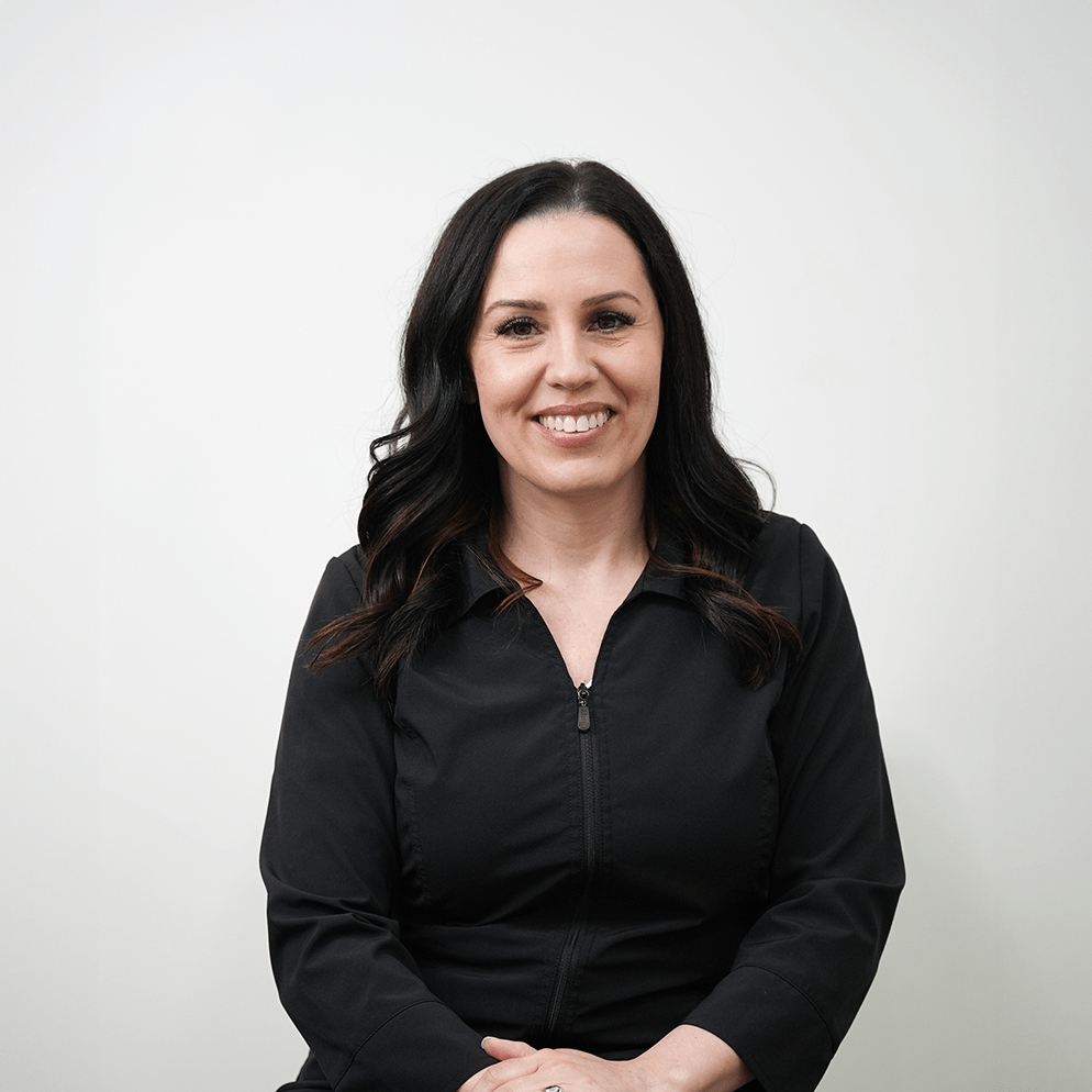 Esthetician Shauna wearing a smock with a beautiful smile.