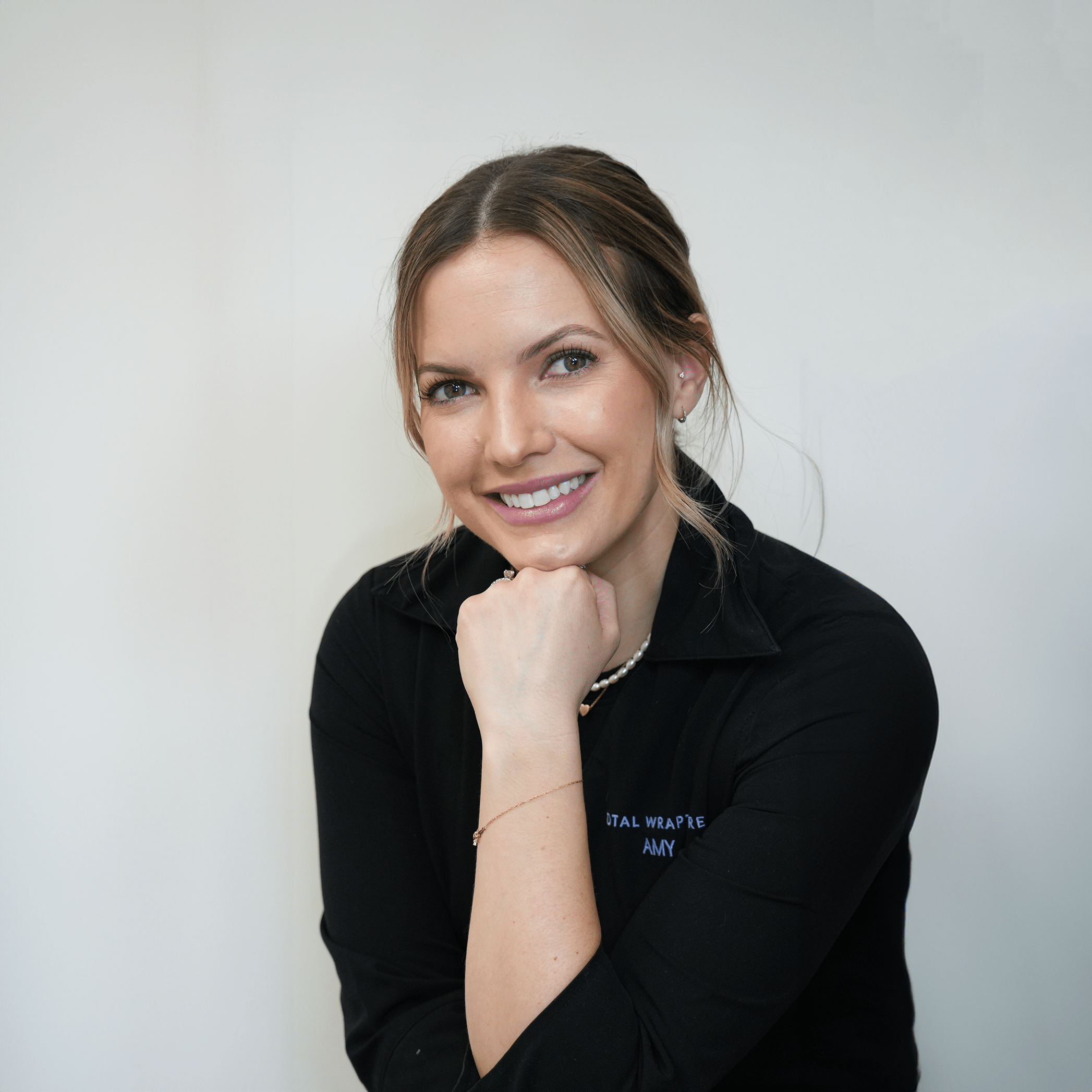 Esthetician Amy wearing a smock with a beautiful smile