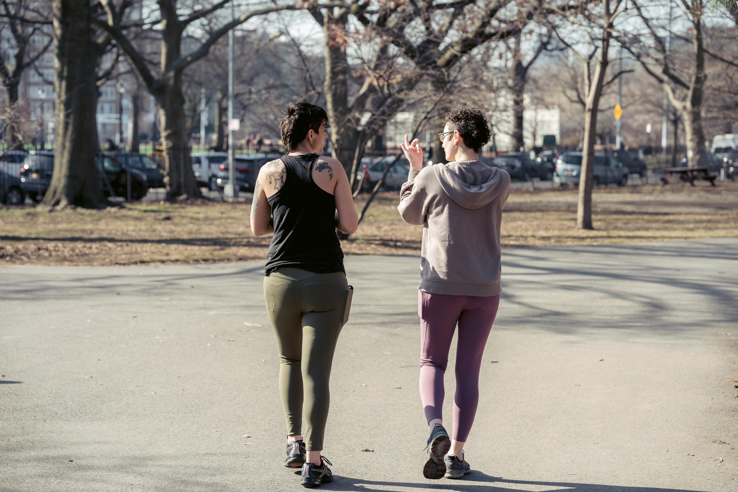 Two persons in activewear walking for exercise 