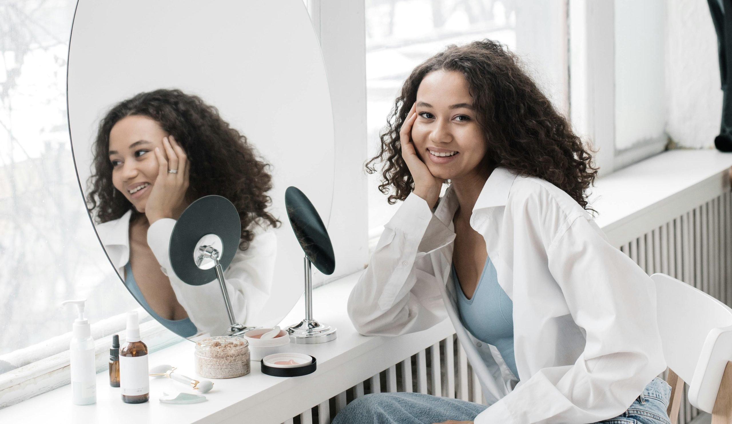 Person with skin that fluctuates with sun exposure seated near mirror