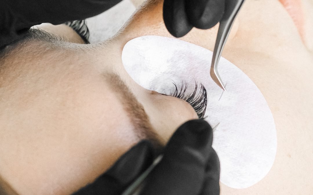 a lash extension service in Winnipeg showing a close-up of an extension about to be placed on a natural lash.