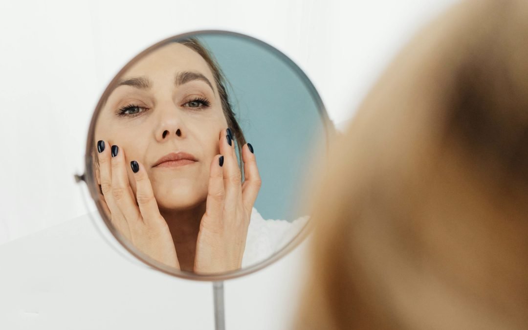 a person looking into a round mirror at her wrinkles