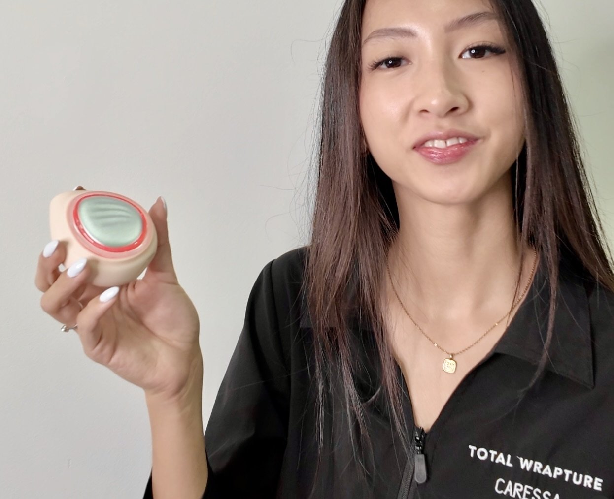 esthetician caressa holding a hadaka led light therapy device